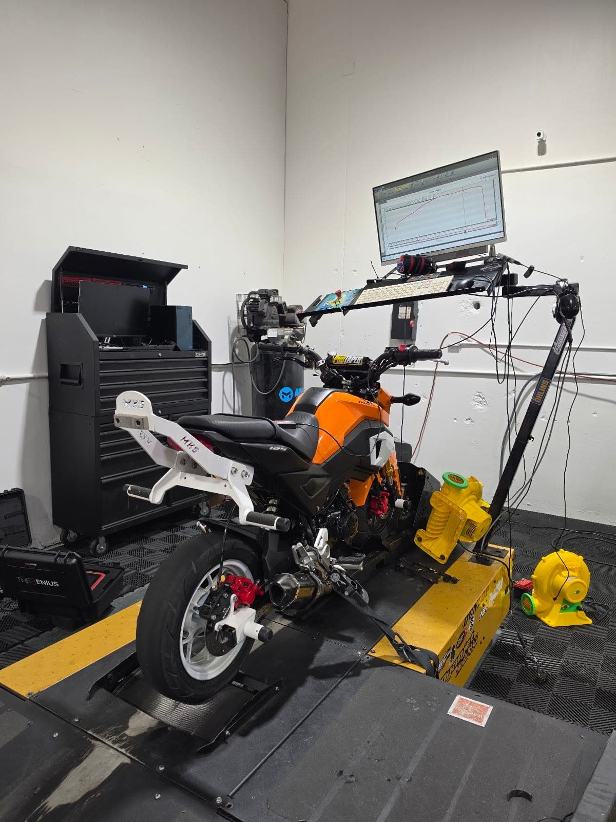 A bike strapped to the dyno at Alter'd Motorsports with the monitor above